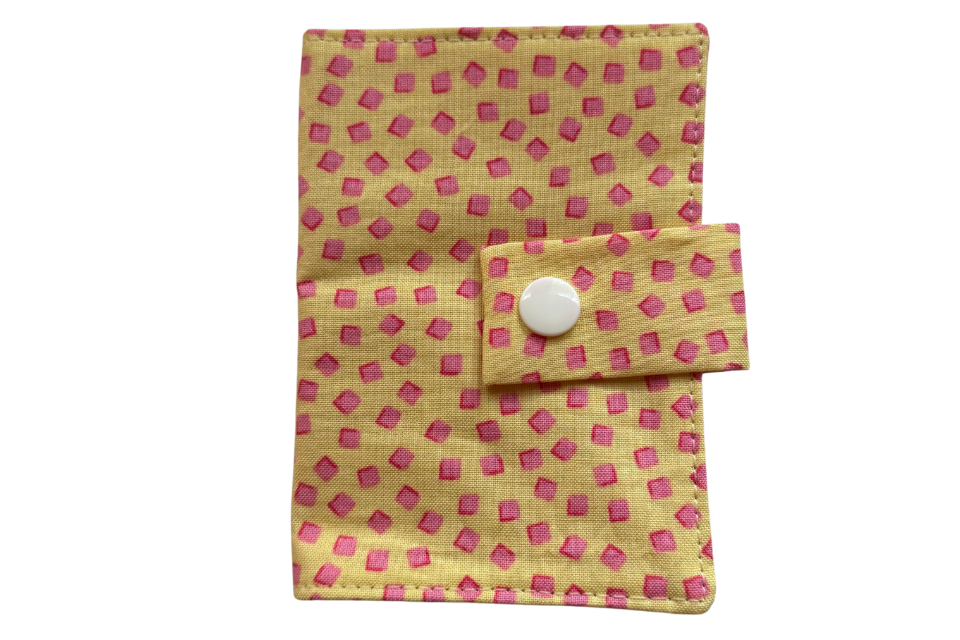 Small fabric pouch to carry tea on the go with pink square pattern on a yellow background