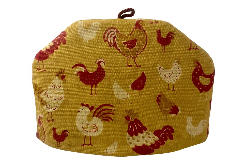 A yellow tea cozy with a pattern of chicken illustrations on it.