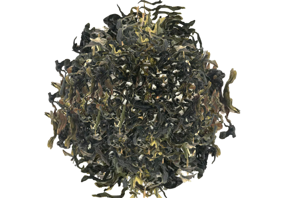 Dry green tea leaves on a white background