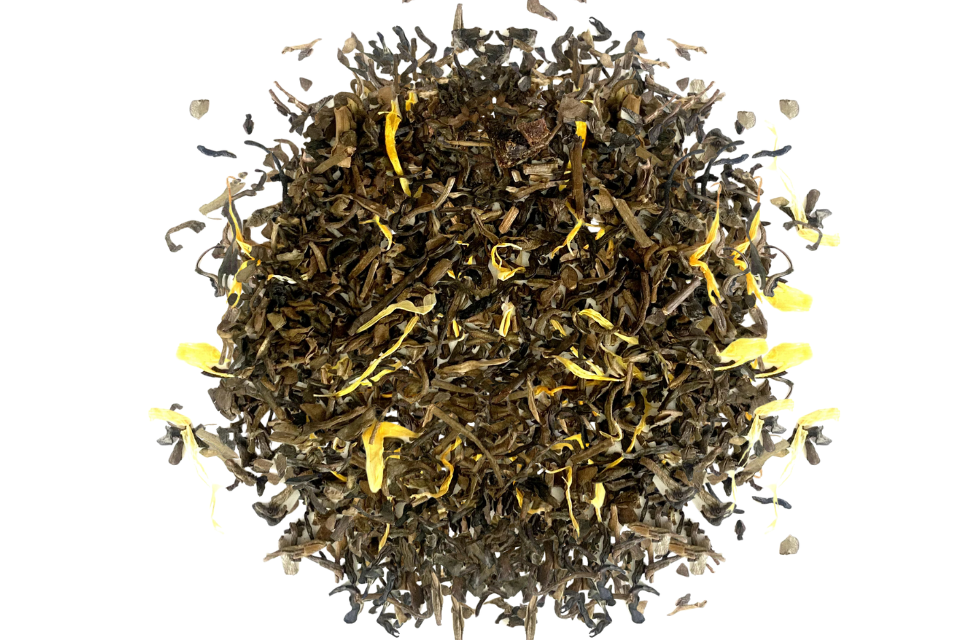 Dry decaffeinated tea leaves with yellow flowers, apricot flavoring on a white background
