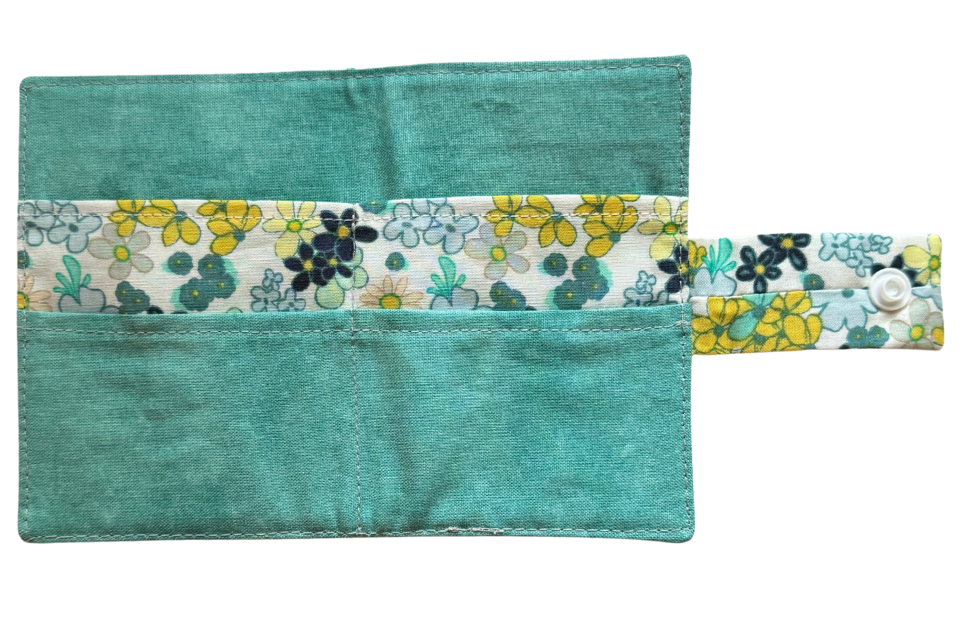 Teal fabric pouch with floral strap on a white background
