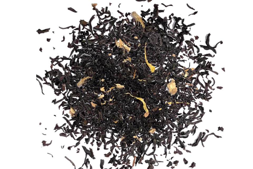 A pile of loose-leaf tea blend with dark brown to black tea leaves and small pale yellow dried flower petals, photographed on a solid white background.