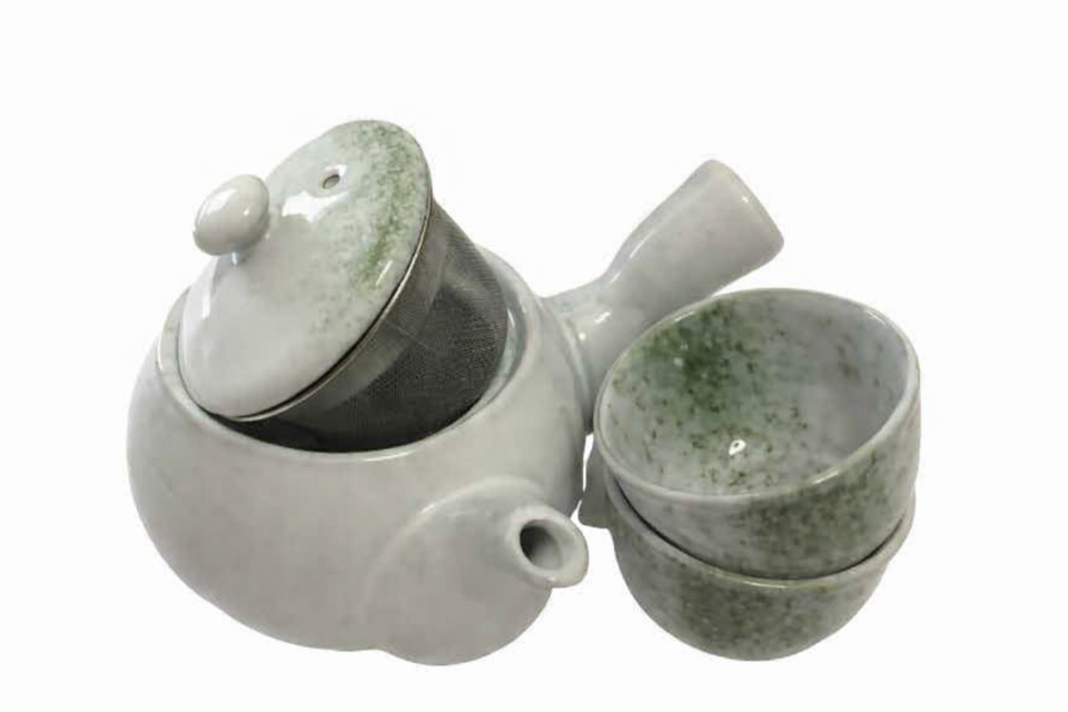 Ceramic teapot with matching cup on a white background