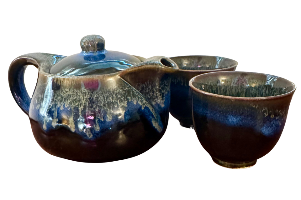 Ceramic teapot set with two cups on a white background