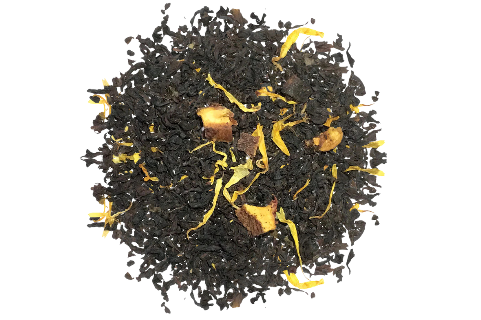 A pile of black tea leaves with pieces of peach and marigold flowers intermixed.