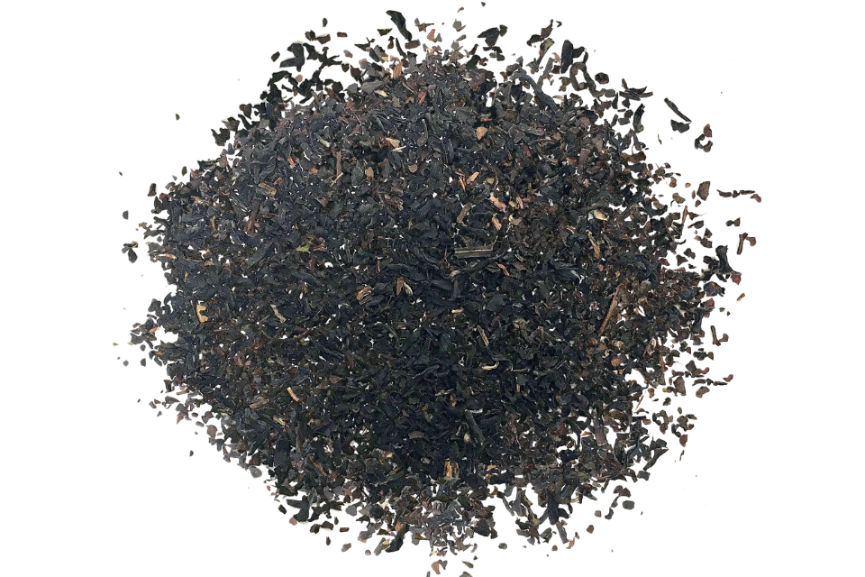 A pile of loose black tea leaves on a white background.