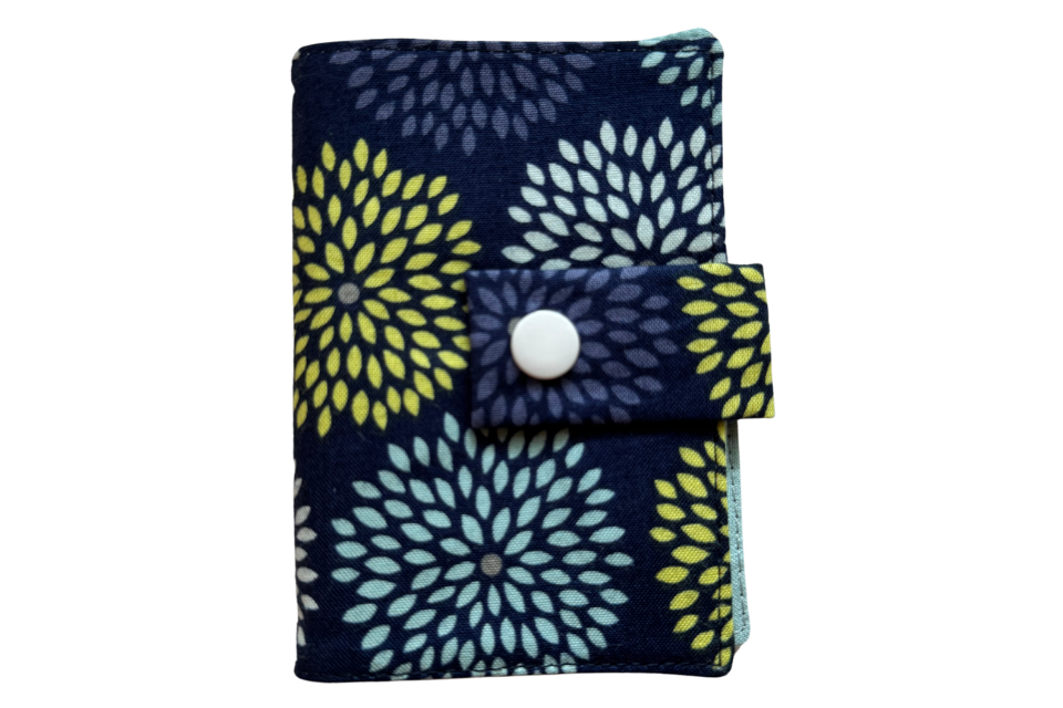 A small travel wallet for tea with a blue burst pattern. The wallet has 4 compartments.