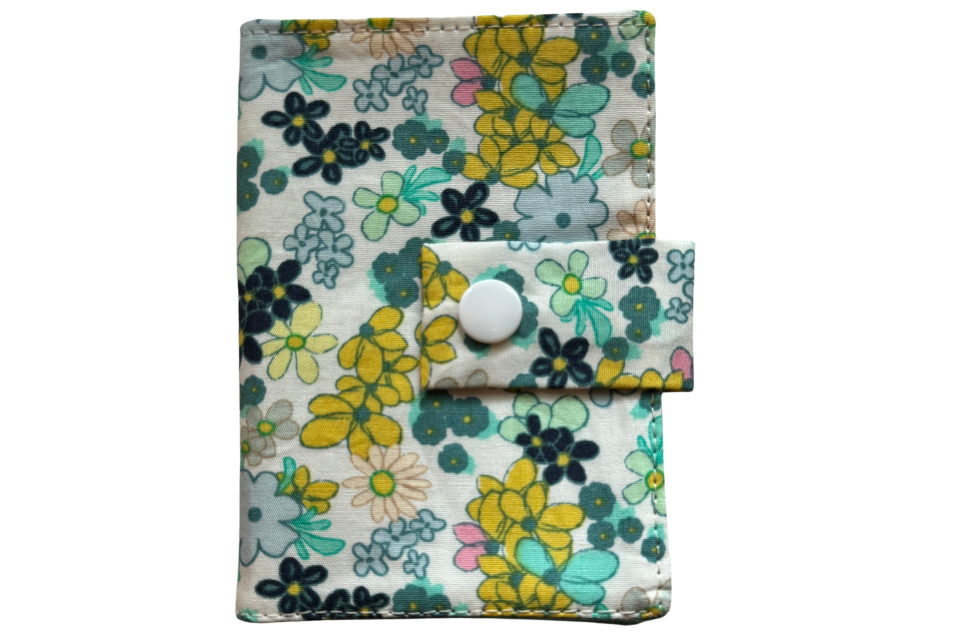 Floral patterned fabric pouch with a button on a white background