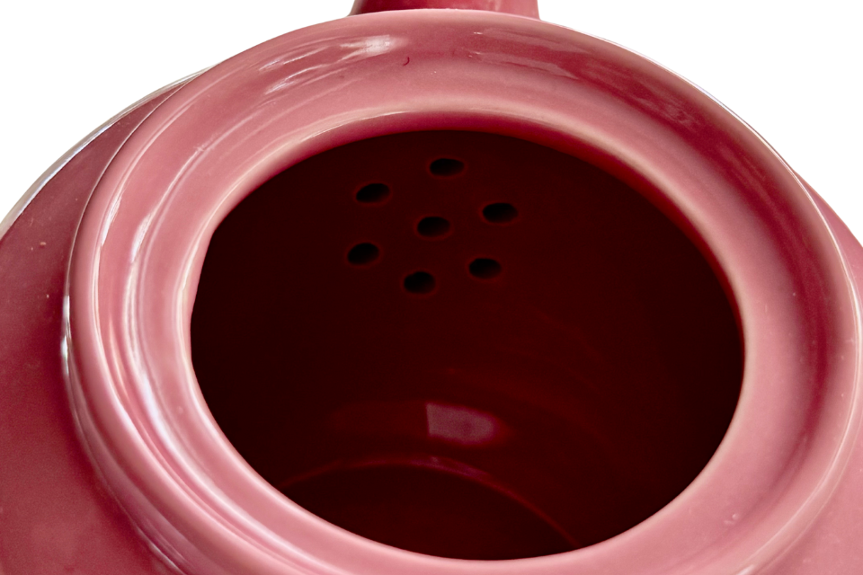 A close up of a dusty rose teapot 