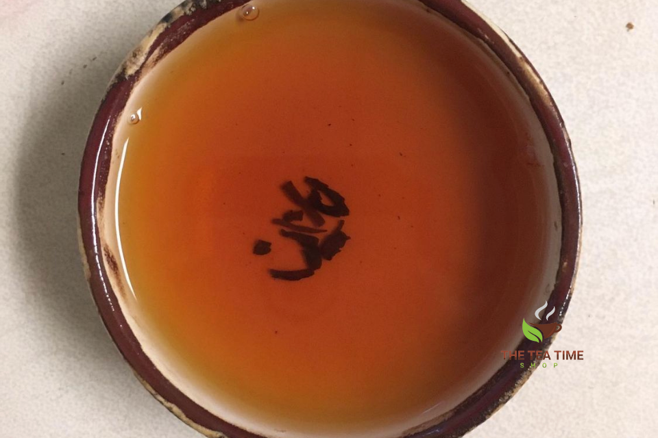 cup of black tea with some tea leaves