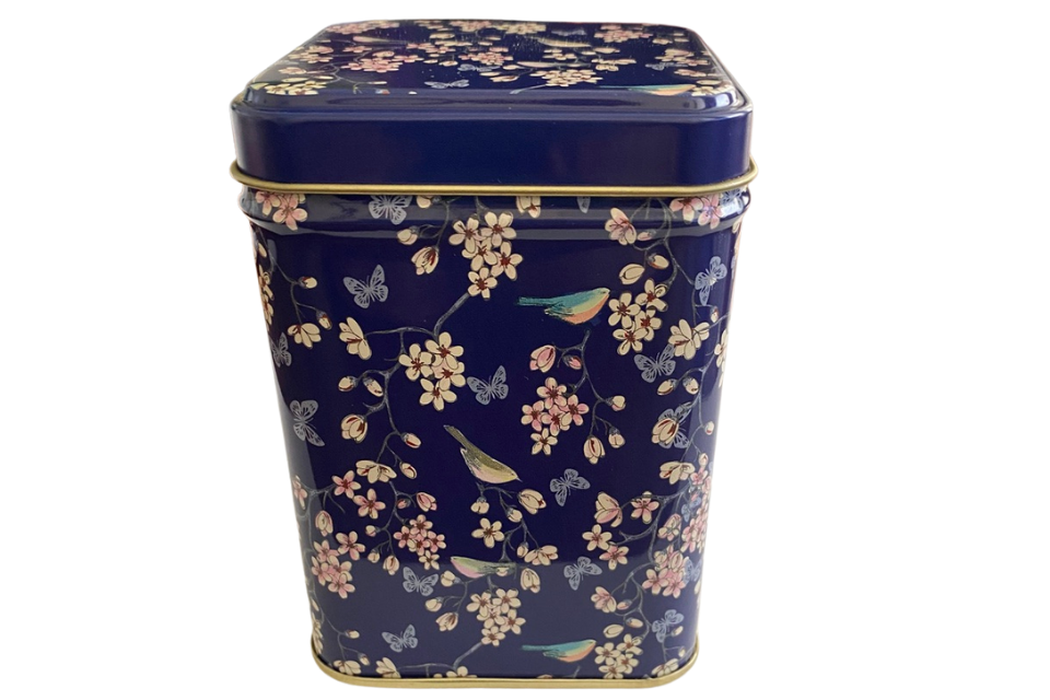 a blue tea canister with a pattern of butterflies and blue birds