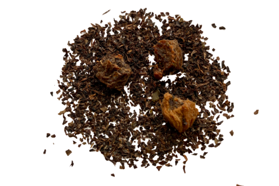 A close-up image of decaf loose leaf black tea with pieces of dried apricot mixed in.