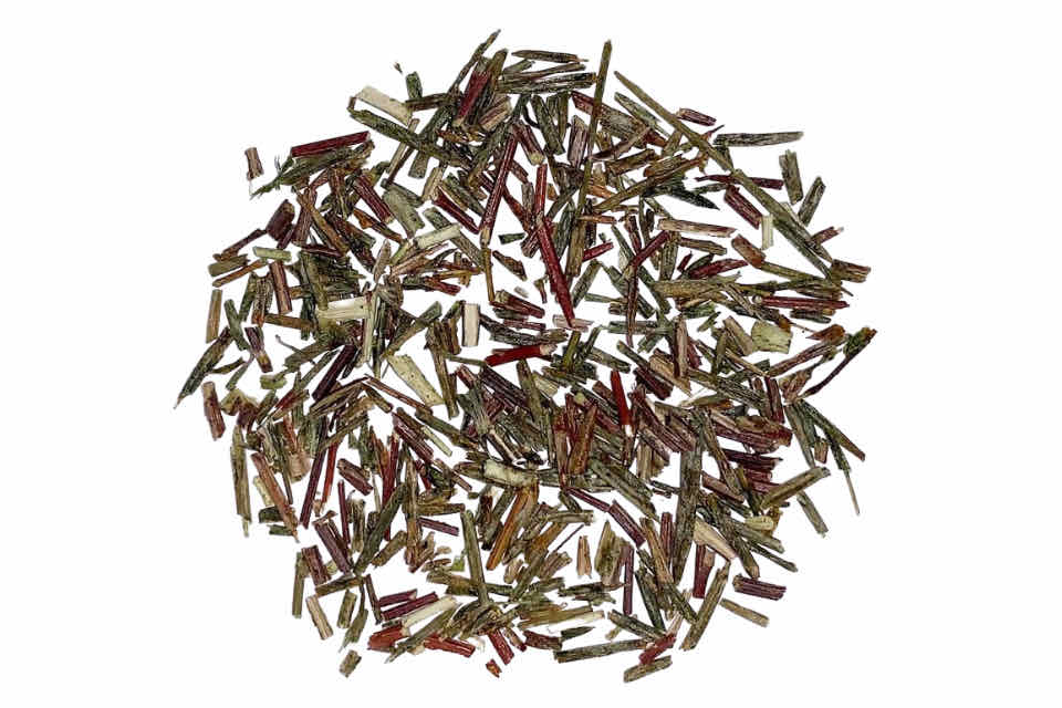 A heap of dried green rooibos leaves.