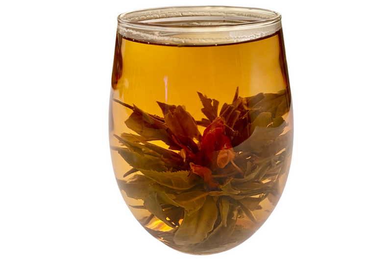 guava blooming tea ball in a glass cup with an amaranth flower bloomed inside