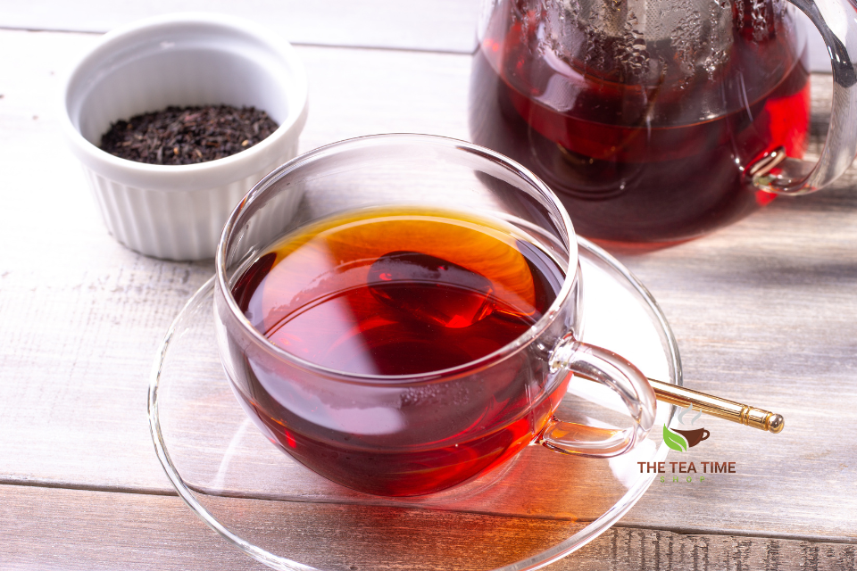 a glass cup and teapot with tea
