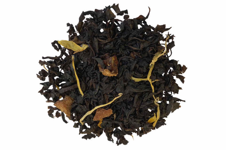 A top-down image of a cup of Apricot Black Tea, showing the tea leaves, apricot pieces, and marigold petals.