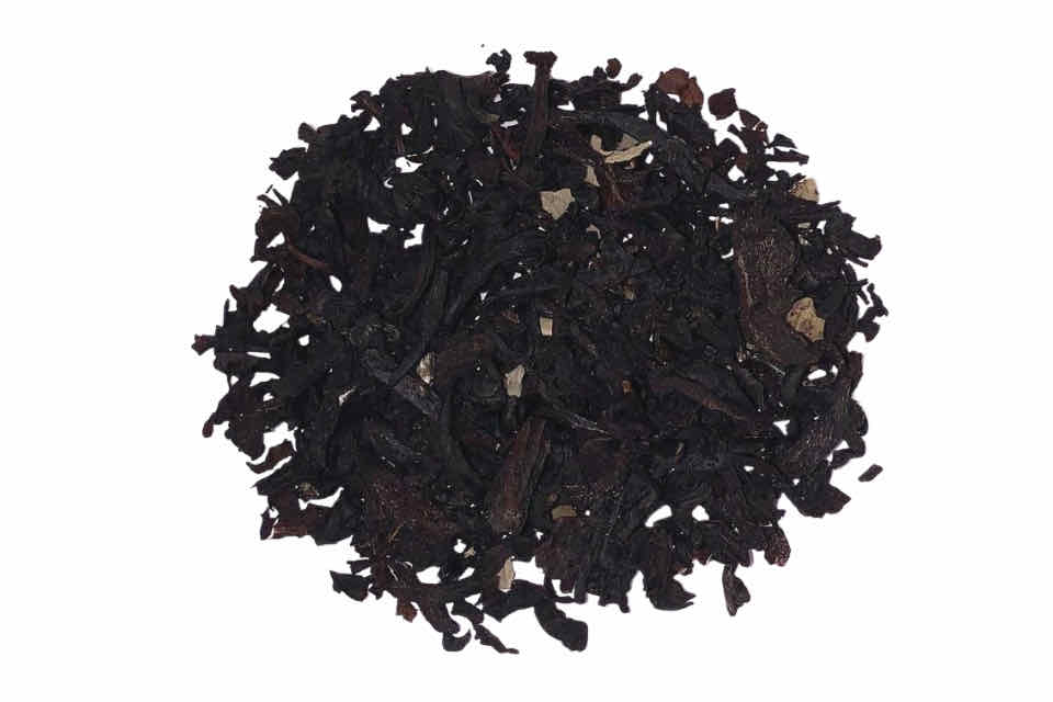 A heap of loose black tea leaves with visible bits of dried blackberry fruit.
