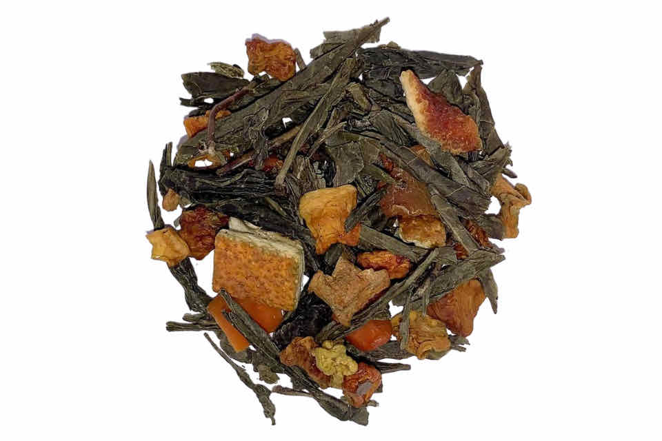 A close-up of Citrus Sunrise Green Tea with visible green tea leaves, pumpkin cubes, orange peel, and other citrus fruit pieces.