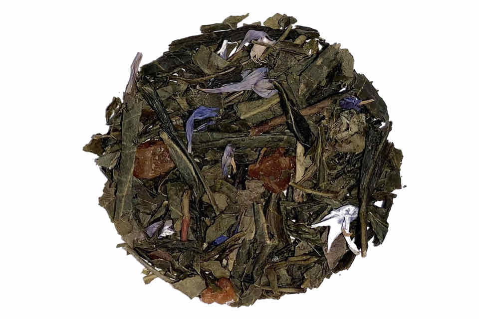 A close-up of Serenity Green Tea leaves with pieces of pineapple and papaya, and blue flowers visible.