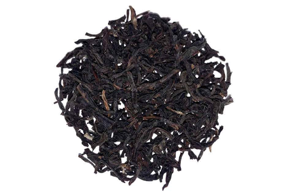 A close-up image of dried black tea leaves.