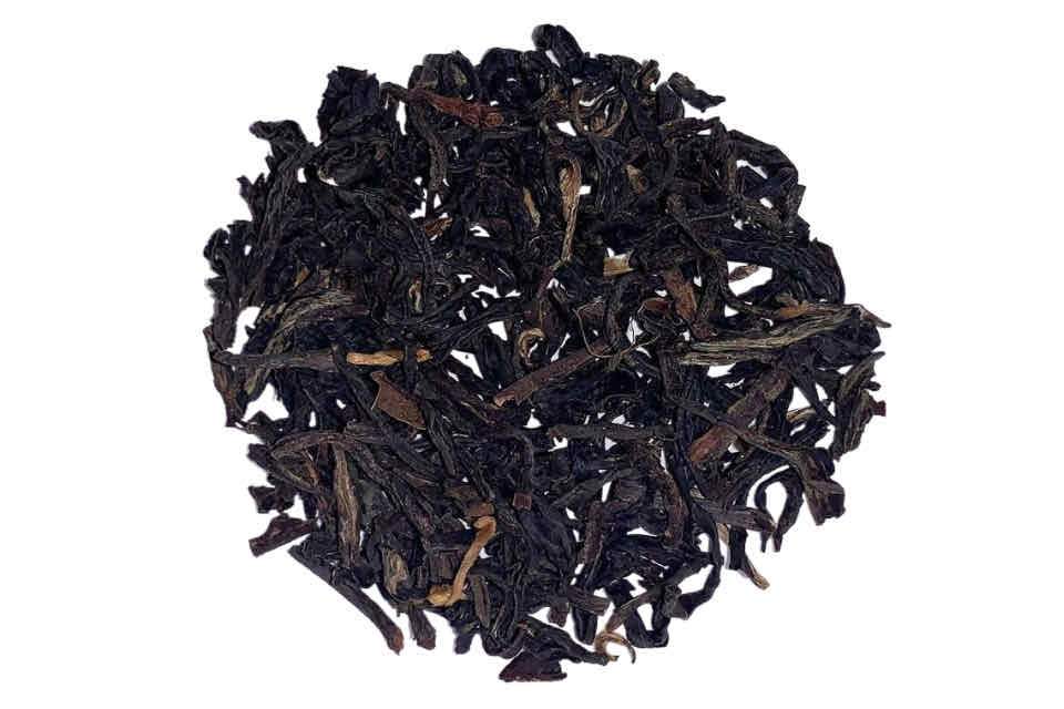 A close-up image of Irish Breakfast Blend tea leaves, showing dark black and golden tips.