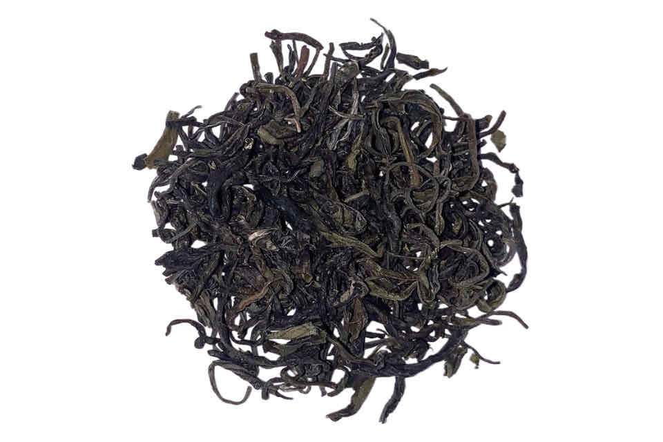 A close-up image of jade cloud dried needle-like green tea leaves.