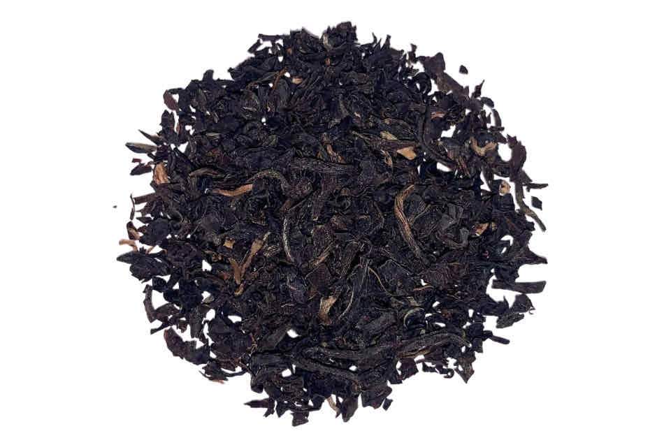 A heap of broken black tea leaves with some gold tips.