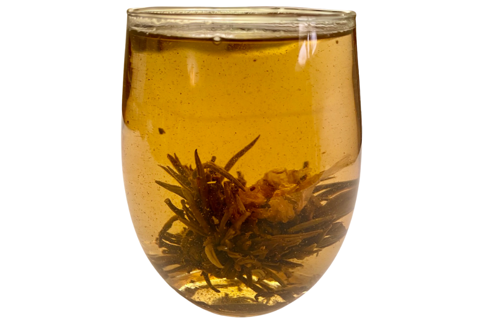 a lotus flower green tea ball in a glass cup
