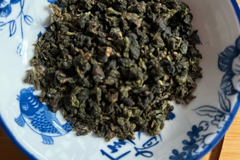 A pile of green oolong tea in a bowl. The Tea Time Shop