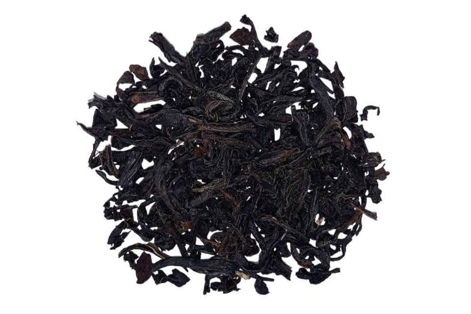 A close-up image of dried black tea leaves.