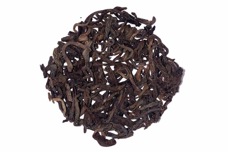 long wiry brown tea puerh tea leaves on a white background