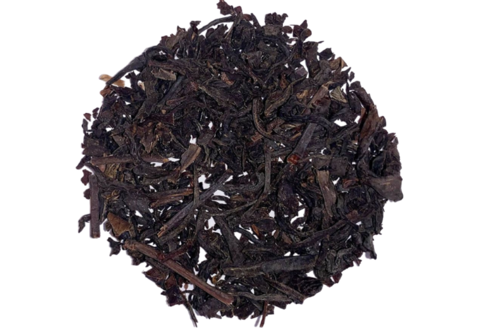 A pile of smoked tea leaves and stems, with a dark brown color and a subtle smoky aroma.