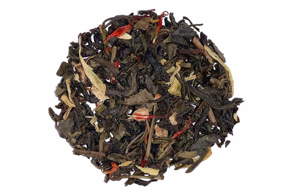 A close-up of Sun-Kissed Ginger Peach Premium Tea leaves, showcasing black tea leaves interspersed with pieces of ginger, orange peels, and marigold petals.