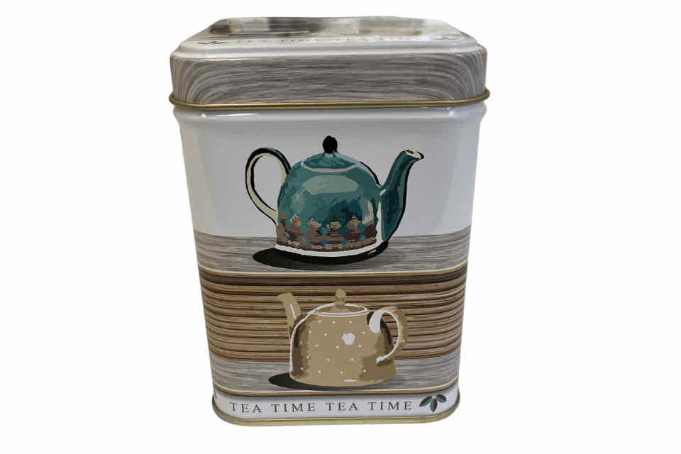 A cylindrical tea storage canister with a 'TEA TIME' label, featuring a pattern of a teapot, cup, and saucer on its side.