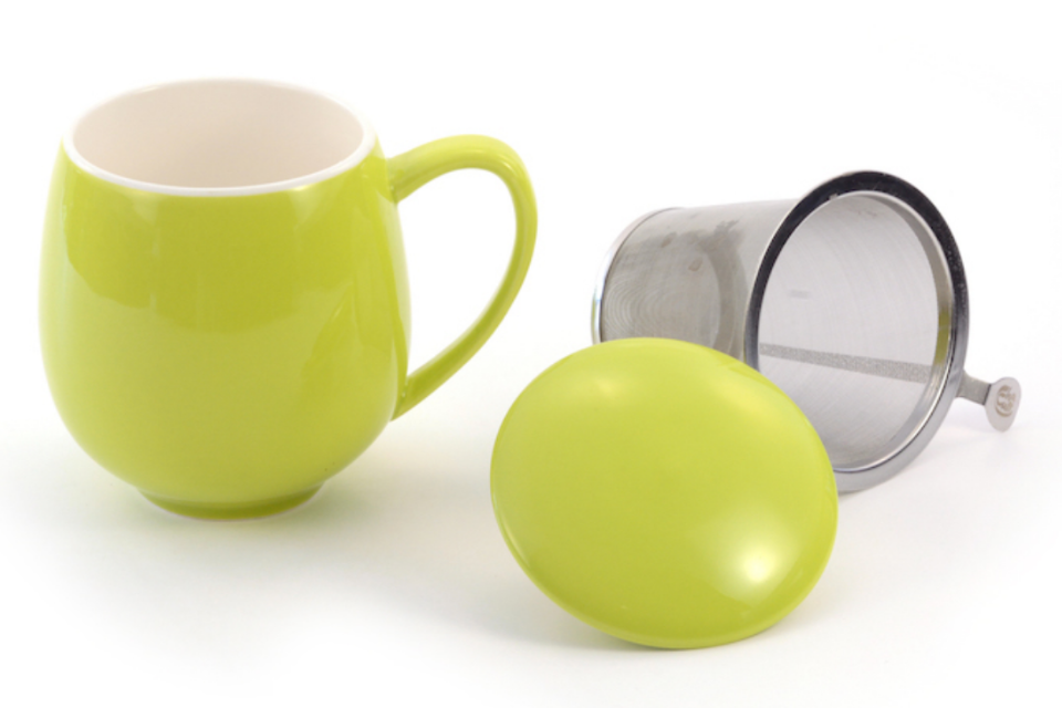A green tea cup with an infuser basket on a white background.