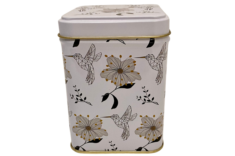 a white tea canister with a pattern of white doves and white flowers