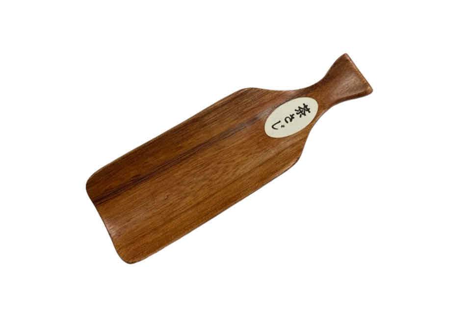 A wooden tea scoop with a handle and a branded tag on the side.