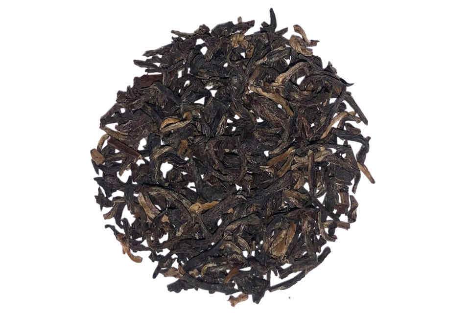 A close-up image of Yunnan Premium Gold Black Tea leaves with some golden tips visible.